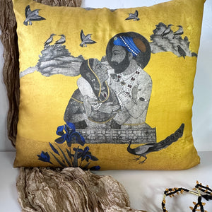 An 18x18 miniature art cushion cover by Sumaira Tazeen featuring a royal Mughal couple portrait on a shimmering gold background with blue floral accents.