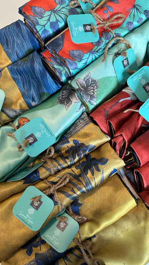 A collection of colorful Mughal art cushion covers in various botanical and bird prints, featuring the Heron, Peacock, Gaze Iris, Gaze Peacock and Rani designs.