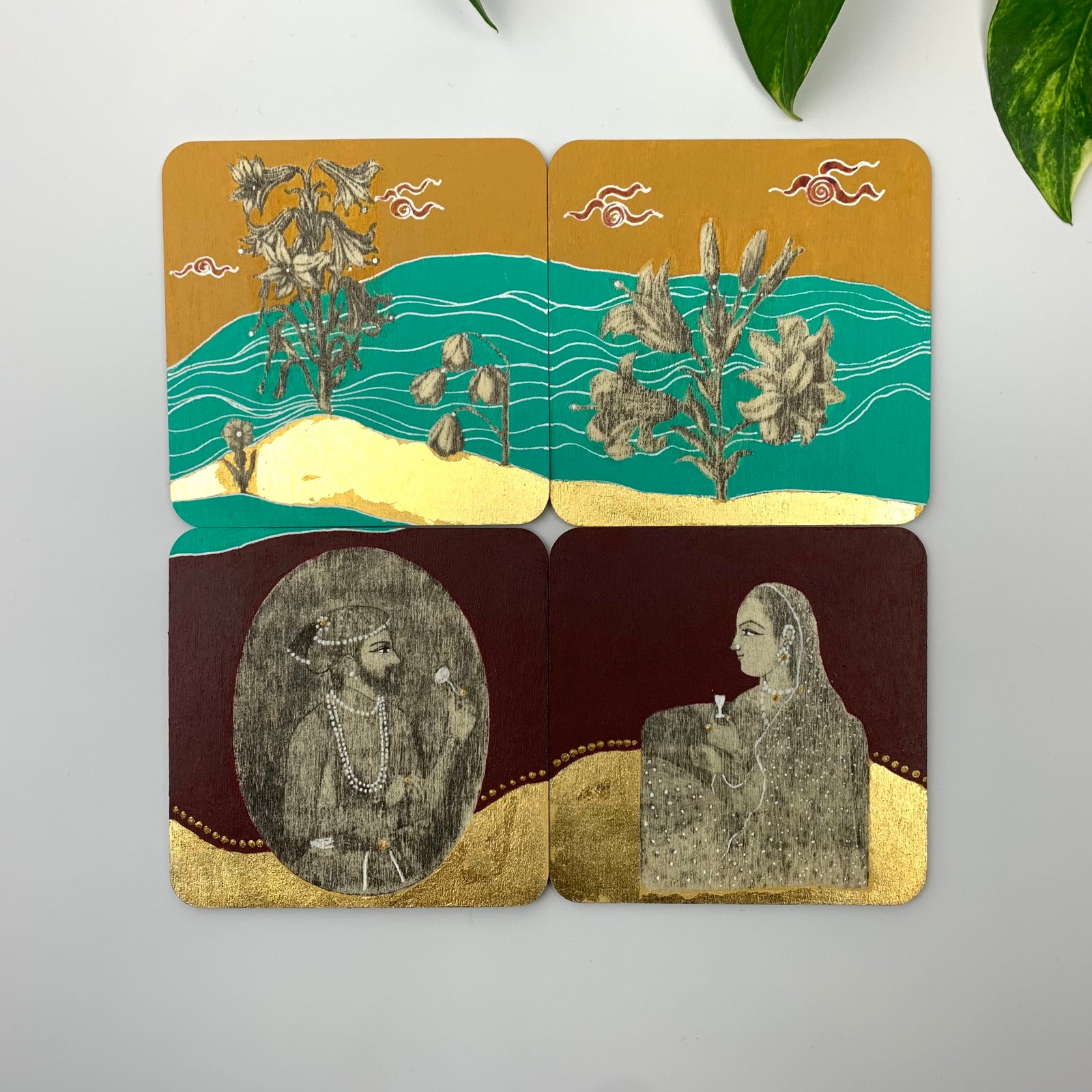 A set of 4 hand-painted coasters featuring the Lets Meet by the Flowers motif with botanicals, regal figures, and gold leaf accents on burgundy and teal backgrounds.