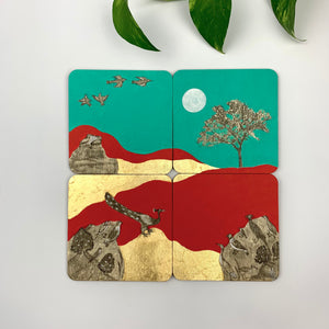 A set of four hand-painted coasters showing a continuous landscape of royal peacocks, flying birds, and gilded trees against teal and crimson backgrounds.