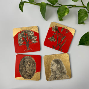 Four hand-painted plywood coasters with vibrant red and gold leaf designs in staggered ararngement.
