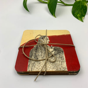 Side view of a set of four hand-painted coasters tied with rustic twine, highlighting the high-quality plywood layers and gold leaf accents.