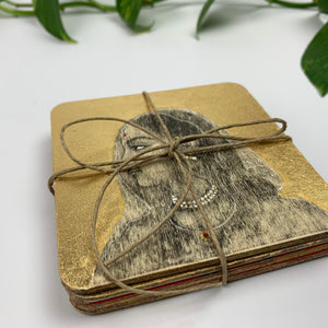 A stacked set of Raja Rani hand-painted coasters tied with rustic twine.