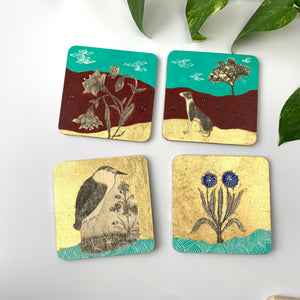 Four hand-painted coasters with unique and exquisite Mughal-inspired designs of flora and fauna spread out on a white surface.